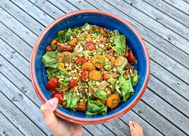 Blue ceramic bowl with fresh, Norwegian vegetables and seeds.  The bowl is photographed from above.